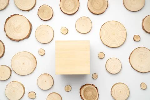 Pine tree cross-sections with annual rings and wooden square on white background Stock Photos