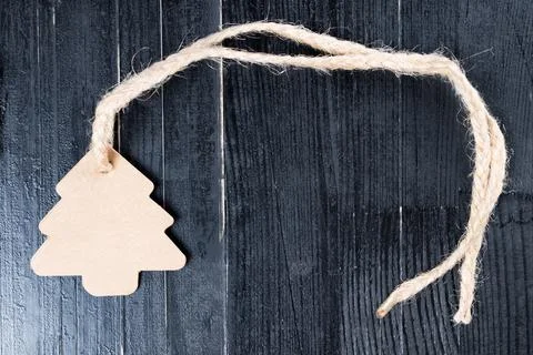 Pine tree label with twine attached on natural black table. Stock Photos