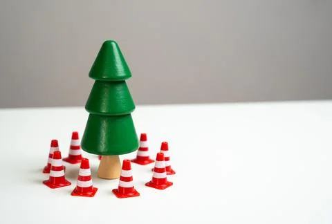 A pine tree is surrounded by traffic cones. Preserve forests from deforestati Stock Photos