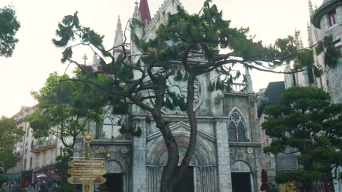 Pine trees surrounding gothic church in ba na hills, vietnam, framing historic Stock Footage 315701876