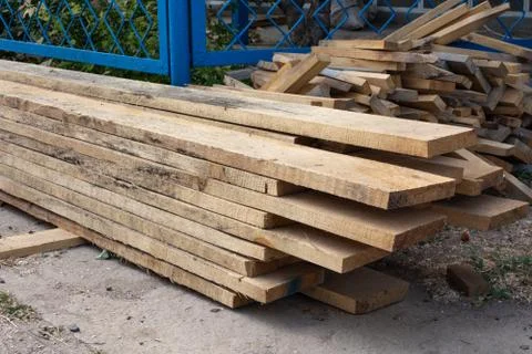 Pine wood timber stack of natural rough wooden boards on building site. Indus Stock Photos