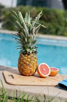 Pineapple and grapefruit on the edge of the pool Foto stock