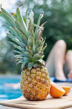 Pineapple and grapefruit on the edge of the pool 스톡 사진