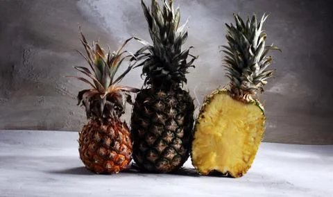 Pineapple and a half of pineapple ruit. vegan delicious snack on white stone  Stock Photos