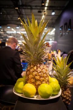 Pineapple and lemons are on a plate on a counter Stock Photos