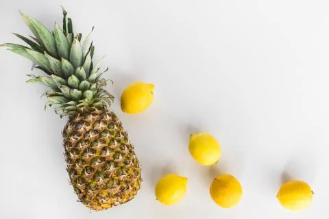 Pineapple and lemons lay flat on white background Stock Photos