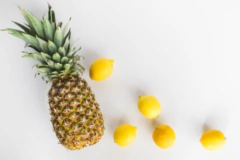 Pineapple and lemons lay flat on white background Stock Photos
