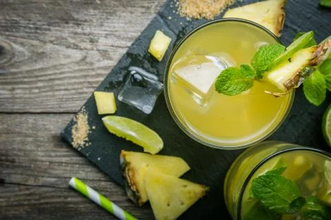 Pineapple and lime drink on rustic background Stock Photos