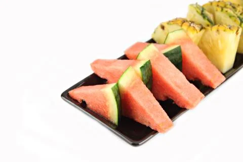 Pineapple and watermelon slice arranged in the black dish. Stock Photos