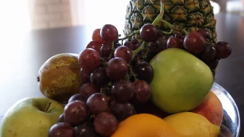 Pineapple, apple, red grapes, lemon, orange. the camera moves around this to the Stock Footage 114702337