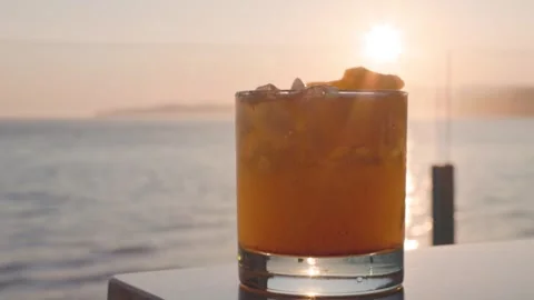 Pineapple cocktail with a sunset ocean view backdrop, beautiful vista, luxury Stock Footage 246609918