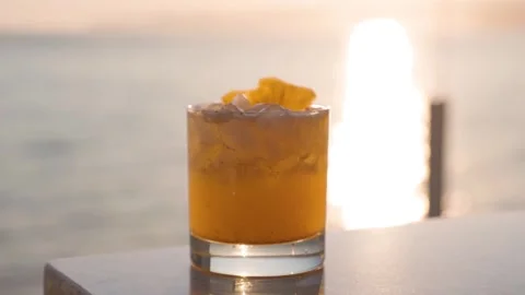 Pineapple cocktail with a sunset ocean view backdrop, beautiful vista, luxury Stock Footage 246610019