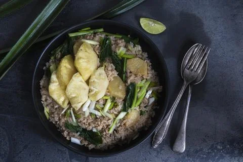 Pineapple fried rice has minced pork and vegetable in plate on stone table. Stock Photos