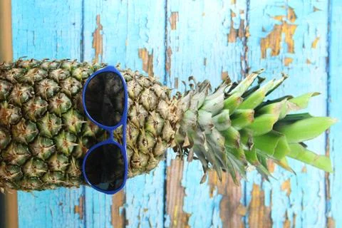 Pineapple fruit with blue  sunglasses Stock Photos