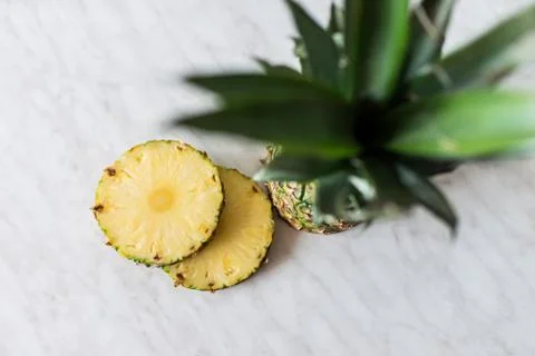 Pineapple fruit with sliced pineapple fruit on the white table. Stock Photos