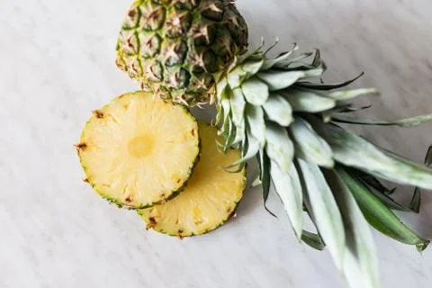 Pineapple fruit with sliced pineapple fruit on the white table. Stock Photos