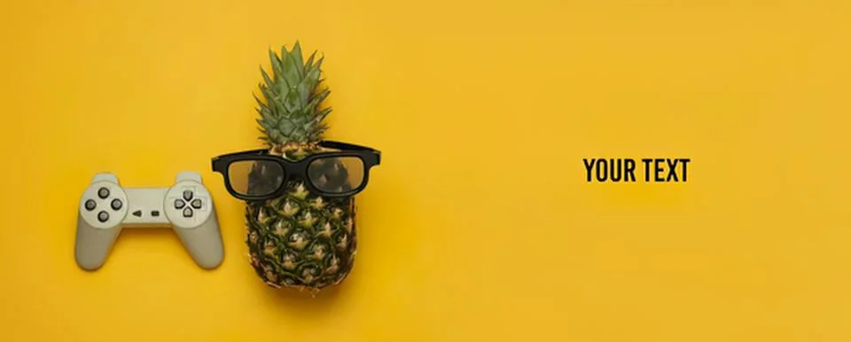 Pineapple with glasses and game controller on yellow background Stock Photos