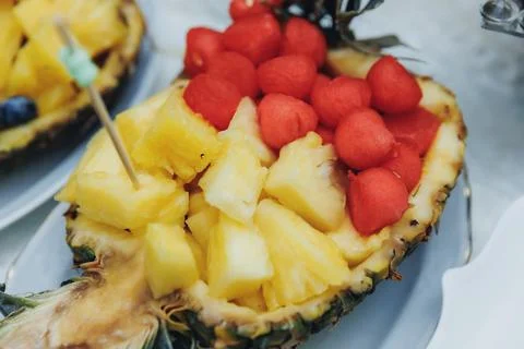 Pineapple half filled with golden fruit pieces Foto stock