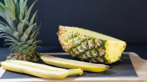 A pineapple half on a stone-framed stone board is cut in half Stock Photos