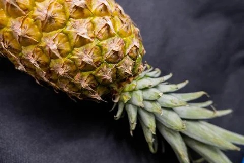 Pineapple isolated on a table with dark tablecloth Stock Photos