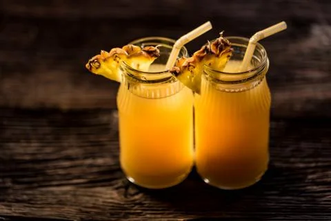 Pineapple juice and slice placed on a wooden table Stock Photos