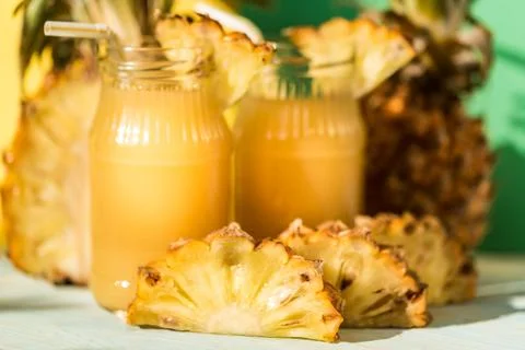 Pineapple juice and slice placed on a wooden table Stock Photos