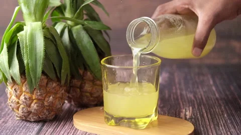 Pineapple juice in a bottle on table Stock Footage 163436375