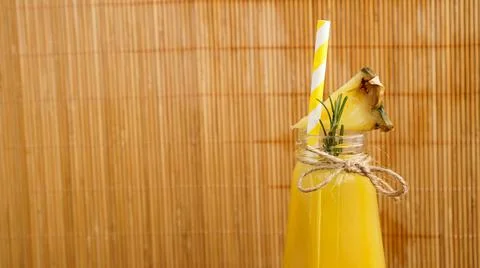 Pineapple juice in a small bottle. Pineapple slices decorate the drink Stock Photos