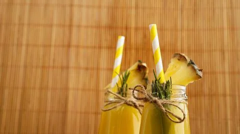 Pineapple juice in a small bottle. Pineapple slices decorate the drink Stock Photos