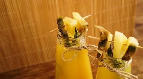 Pineapple juice in a small bottle. Pineapple slices decorate the drink Stock Photos
