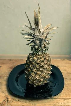 Pineapple on the kitchen table in a plate Stock Photos