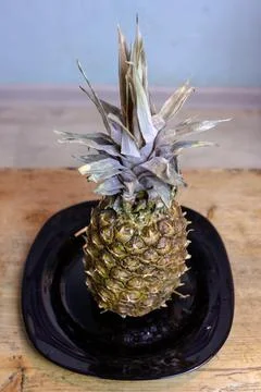 Pineapple on the kitchen table in a plate Stock Photos