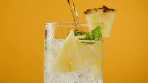 Pineapple lemonade on orange background. Fruit ananas cocktail close-up texture Stock Footage 196936414