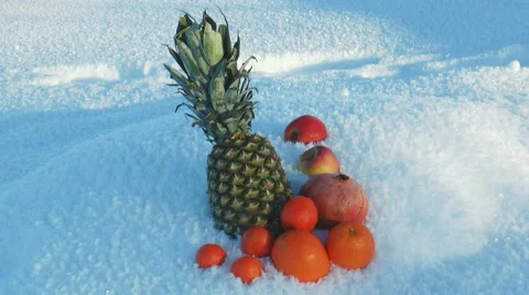 Pineapple lies in fluffy snow,surrounded by various fruits. Stock Footage 64288438