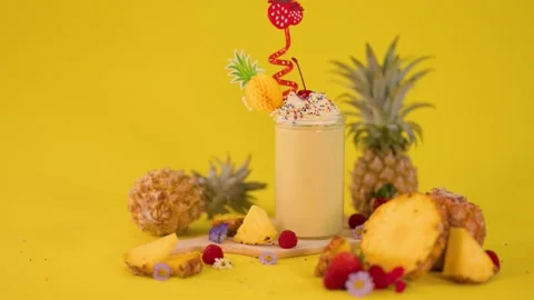 Pineapple Milkshake with Whipped Cream and Cherry on Yellow Background Stock Footage 322157311