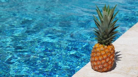 Pineapple near swimming pool at poolside 動画素材 303343721
