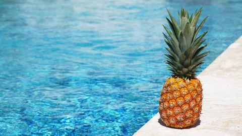 Pineapple near swimming pool at poolside. Summer holidays 動画素材 304289229