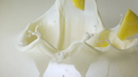 Pineapple pieces falling in milk and splashing Stock Footage 149434270