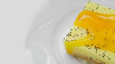 Pineapple pudding with poppy and jam, rotating on a white plate Stock Footage 54338800