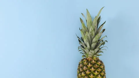 Pineapple rolling on pastel blue theme. Stop motion Stock Footage 141164772
