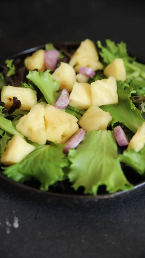 Pineapple Salad mixed green salad leaves and pineapple chunks food preparation Stock Footage 341160028