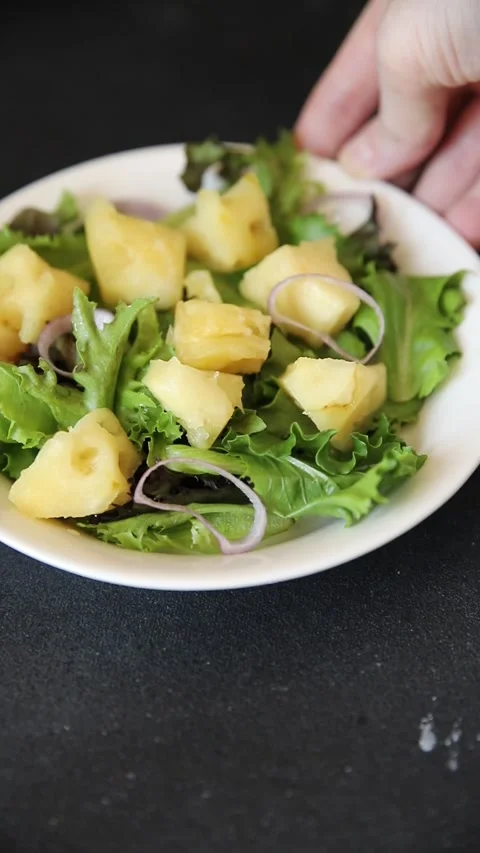 Pineapple Salad mixed green salad leaves and pineapple chunks food preparation Stock Footage 341160060