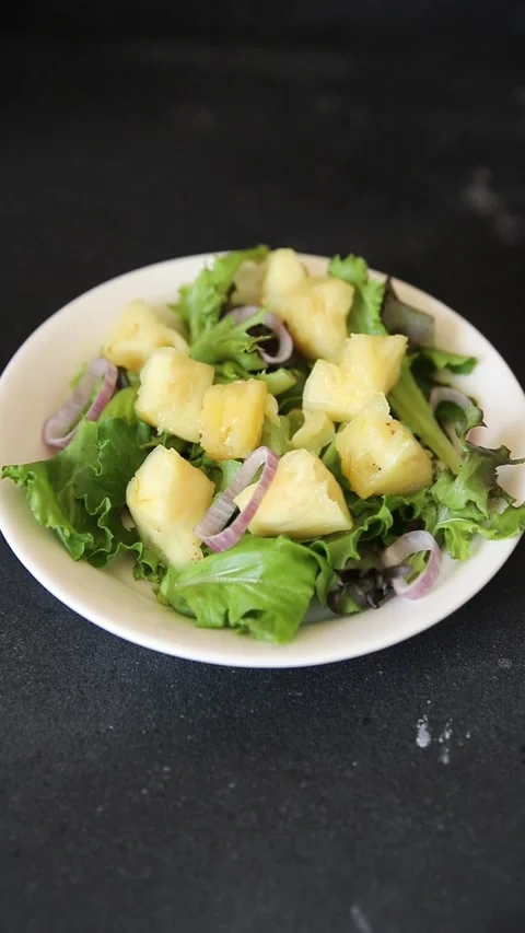 Pineapple salad mixed green salad leaves and pineapple chunks food Stock Footage 343160763