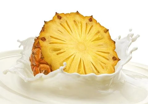 Pineapple slice falling into milk splash isolated on white background Stock Photos