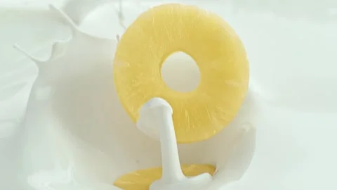 Pineapple Slices Falling into Creamy Milk Making Splashes in Macro Stock Footage 274355204