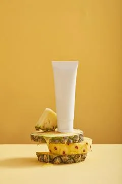 Pineapple slices with round shape are stacked and a white tube with empty lab Stockfoto's