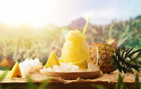 Pineapple slush on a table in field with pineapple crops Stock Photos