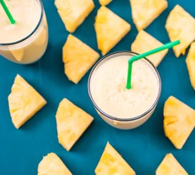 Pineapple smoothie on a blue background Stock Photos