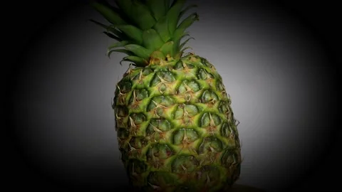 Pineapple spinning on turntable with black vignette 스톡 동영상 184608307