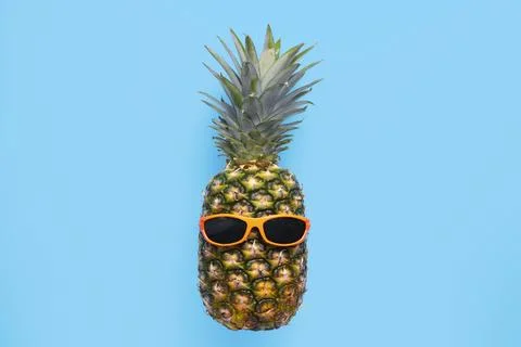 Pineapple with sunglasses on blue background Stock Photos
